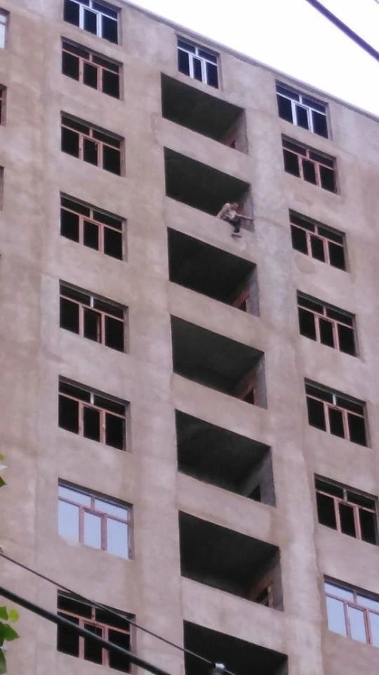 СРОЧНО:В Баку рабочий пытается сброситься с 15 этажа