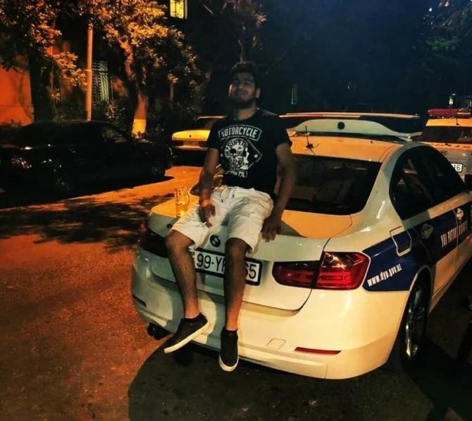 Bakıda polis maşınının kapotunun üzərində pivə içən şəxs saxlanıldı - FOTO