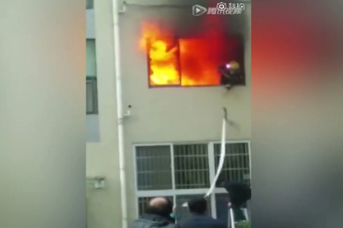 Китайский пожарный выпрыгнул из окна, спасаясь от пламени (видео)