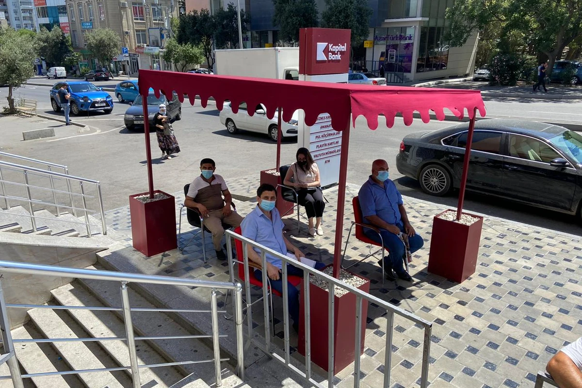 Kapital Bank filialların önündə müştəriləri günvurmadan qoruyur Kapital Bank filialların önündə müştəriləri günvurmadan qoruyur