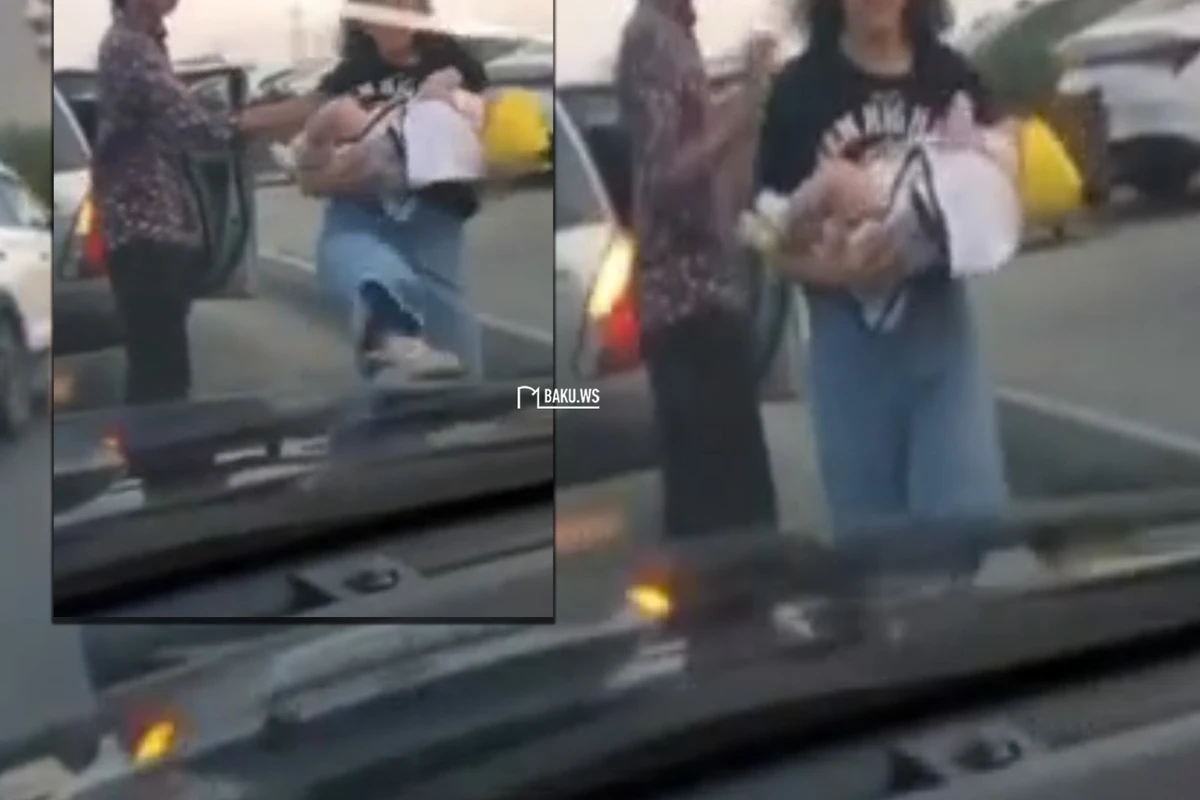 В Баку женщина с ребенком на руках напала на автомобиль - ВИДЕО
